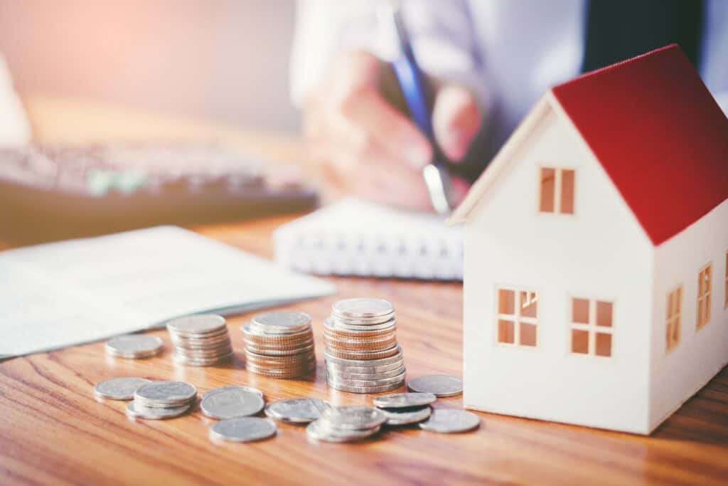 Model home and stacked coins representing home improvement financing